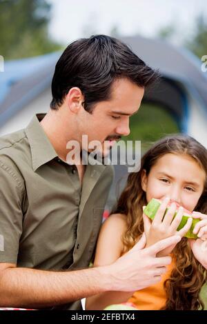 Close-up of a father and his daughter eating a slice of watermelon Stock Photo