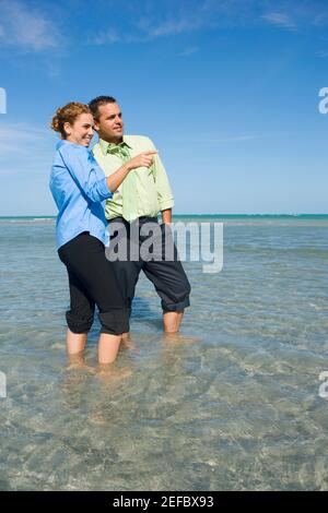 Mid adult couple standing in water Stock Photo