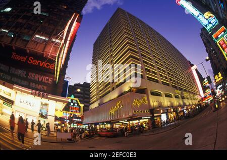 Low angle view of buildings in a city lit up at night, Hong Kong, China Stock Photo