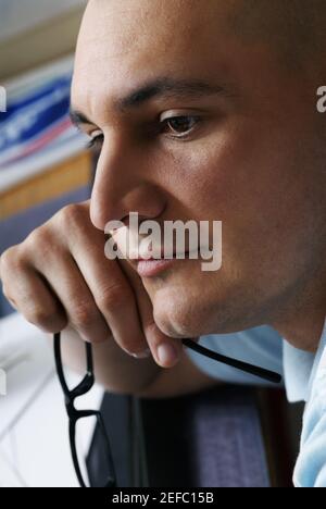 Side profile of a male architect holding eyeglasses and thinking Stock Photo