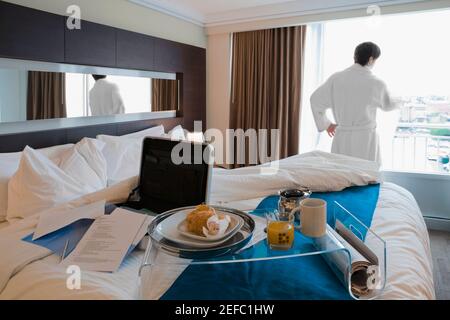 Rear view of a young man looking through a window Stock Photo