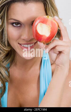 Portrait of a young woman holding a missing bite apple and smiling Stock Photo