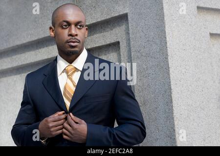 Close up of a businessman buttoning his coat Stock Photo