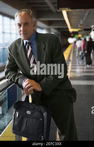 Portrait of a businessman holding a bag and standing at a subway station Stock Photo