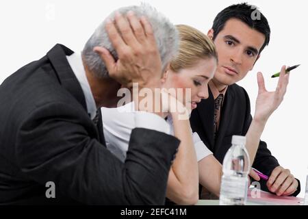 Two businessmen and a businesswoman at a meeting in a conference room Stock Photo