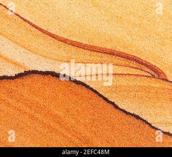 Close-up image of a slab of sandstone showing its layers which produce wave-like patterns. Stock Photo
