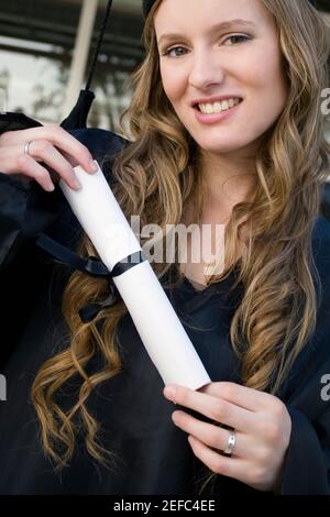 Portrait of a female graduate holding her degree Stock Photo
