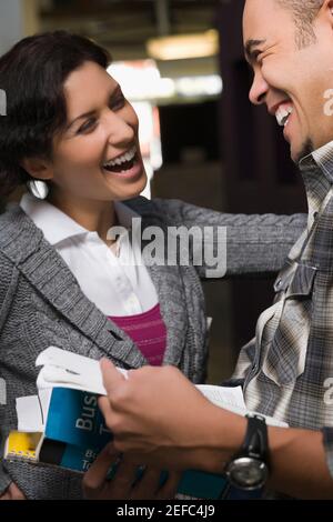 Two university students talking and smiling in a corridor Stock Photo