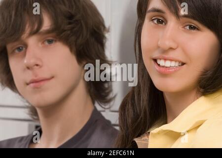 Portrait of a teenage boy and a teenage girl smiling Stock Photo