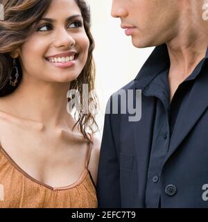 Close up of a young woman looking at a mid adult man and smiling Stock Photo