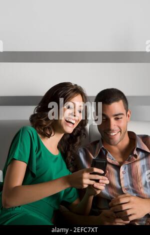 Young couple using a mobile phone and smiling Stock Photo