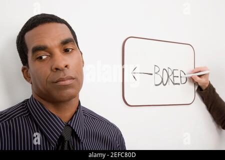 Businessman thinking with a personÅ½s hand writing on a whiteboard Stock Photo