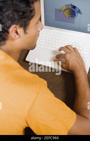 Rear view of a young man using a laptop Stock Photo