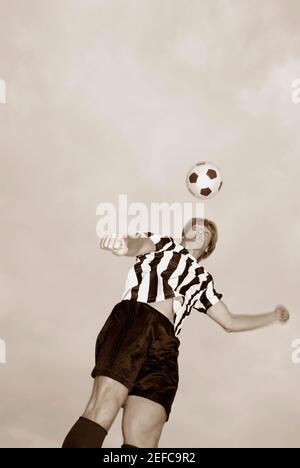 Low angle view of a soccer player heading a soccer ball Stock Photo