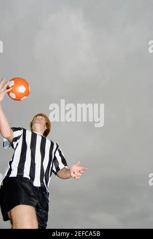 Low angle view of a soccer player tossing a soccer ball Stock Photo