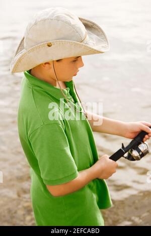 Close-up of a teenage boy holding a fishing rod - Stock Photo