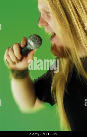 Close-up of a mid adult man singing into a microphone Stock Photo