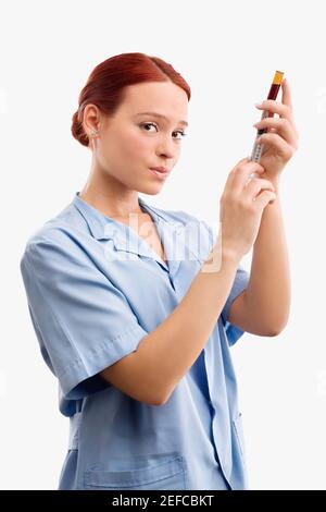Portrait of a female doctor filling a syringe from a vial Stock Photo