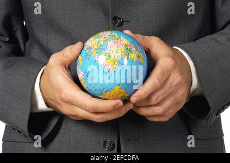 Mid section view of a businessman holding a globe Stock Photo