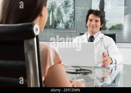 Male doctor talking to a woman in a clinic Stock Photo