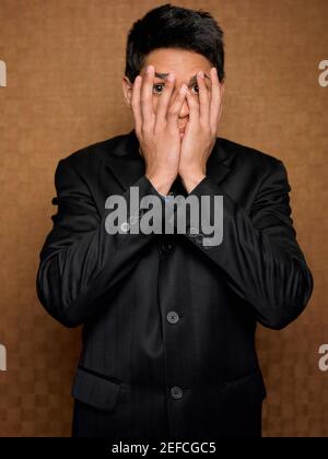 Portrait of a businessman covering his mouth with his hands Stock Photo