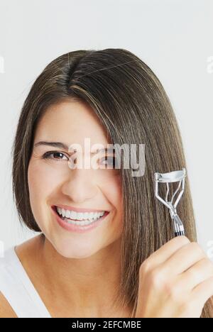 Portrait of a young woman crimping her hair Stock Photo