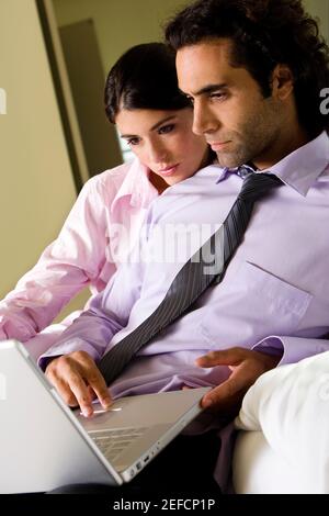 Businessman and a businesswoman using a laptop Stock Photo