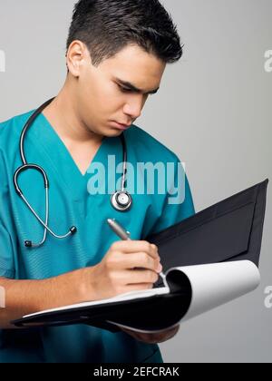 Close up of a male surgeon writing on a medical record Stock Photo