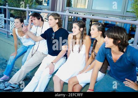 Group of friends sitting on a ledge Stock Photo