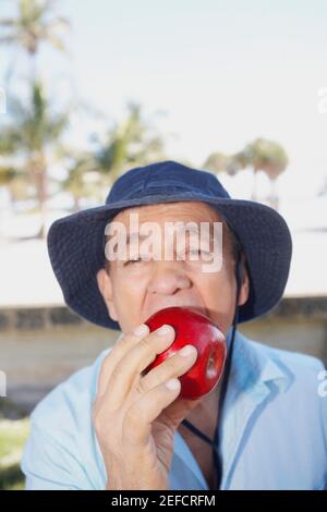 Portrait of a senior man eating an apple Stock Photo