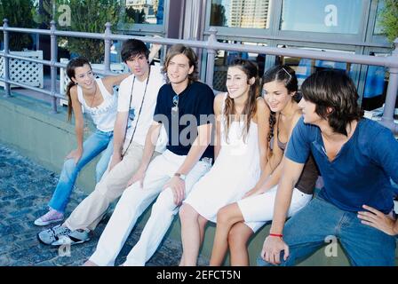 Group of friends sitting on a ledge Stock Photo