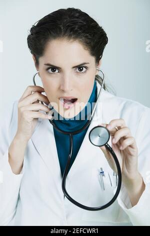 Portrait of a female doctor holding a stethoscope and making a face Stock Photo