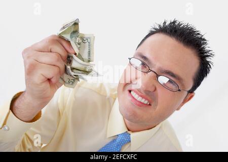 Portrait of a businessman crushing five dollar bills Stock Photo