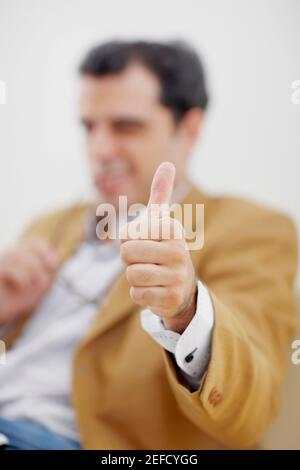 Mid adult man giving a thumbs up sign Stock Photo