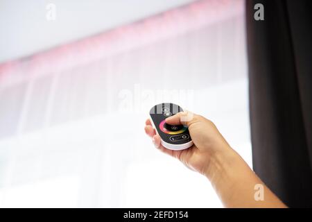 Hand with Remote control on off. LED light Remote Control. LED illumination Stock Photo
