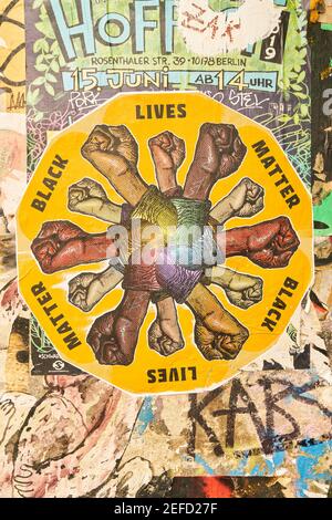 BERLIN, July 2020: Black Lives Matter street art on wall with many fists clenched Stock Photo