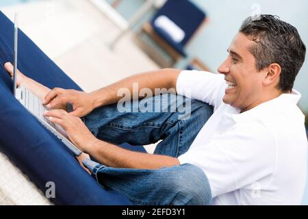 Side profile of a mid adult man using a laptop Stock Photo