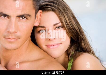 Portrait of a young woman embracing a young man from behind Stock Photo