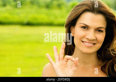 Portrait of a mid adult woman showing an ok sign Stock Photo