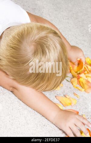 High angle view of a boy picking a rose petal Stock Photo