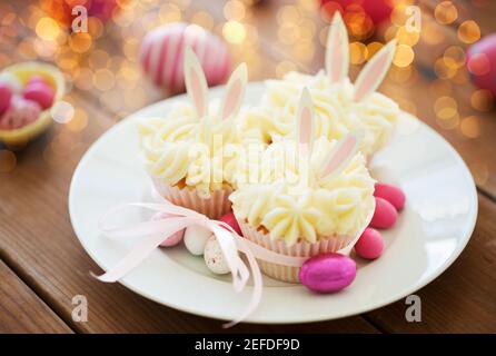 cupcakes with easter eggs and candies on table Stock Photo