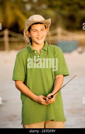 Smiling Teenage Boy Holding Catch Freshwater Fish In Hands Stock