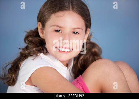 Close-up of a girl hugging her knees Stock Photo