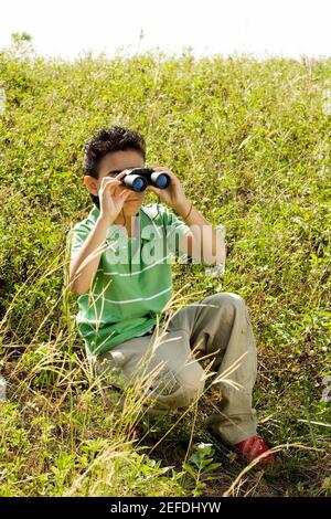 Boy looking through a pair of binoculars Stock Photo