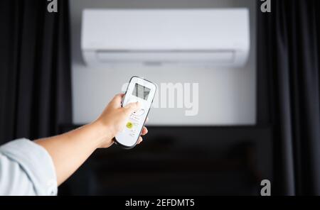 Hand with Remote control on off. Remote Control Directed on the Conditioner Stock Photo