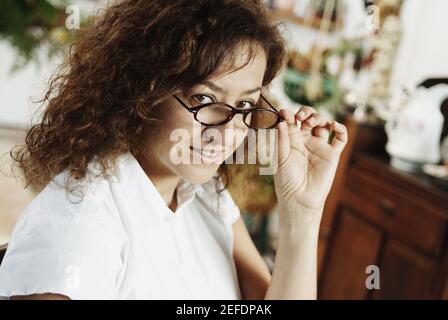 Portrait of a mature woman peeking over her eyeglasses Stock Photo
