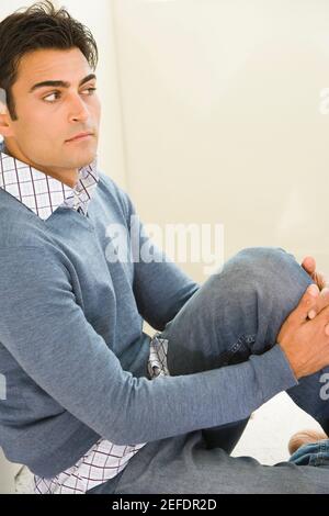 Side profile of a mid adult man sitting on the floor Stock Photo