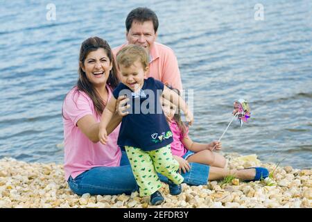 Portrait of a mid adult couple with their two children at the waterÅ½s edge Stock Photo