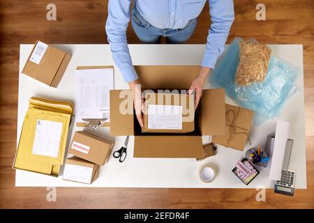 woman packing parcel boxes at post office Stock Photo