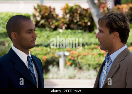Side profile of two businessmen talking to each other Stock Photo